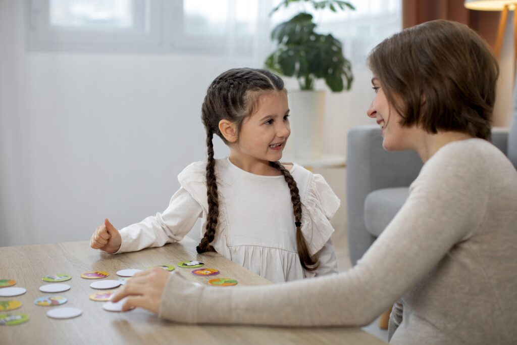 Educadora infantil con una niña realizando un juego para fomentar el aprendizaje cognitivo